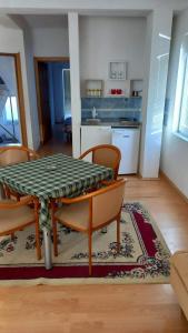 comedor con mesa y sillas y cocina en Apartmani BAKULE, en Peštani
