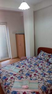 1 dormitorio con 1 cama con colcha de flores en Apartmani BAKULE en Peštani