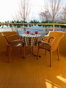 una mesa y sillas con tazas rojas encima en Apartmani BAKULE en Peštani