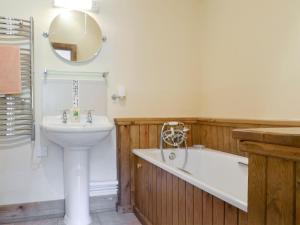 a bathroom with a sink and a tub and a toilet and a bath tub at Shepards Den in East Meon
