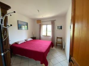 a bedroom with a red bed and a window at Domaine des fouques in Hyères
