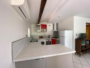 a kitchen with a white counter top and a refrigerator at Domaine des fouques in Hyères