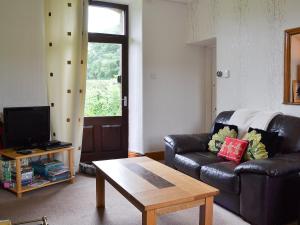 a living room with a leather couch and a coffee table at Ticket Office in Torver