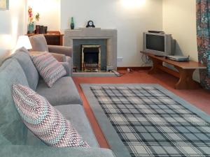 a living room with a couch and a fireplace at Bluebells in Strathpeffer