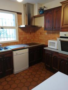 a kitchen with wooden cabinets and a white appliance at La villa les oliviers in Vidauban