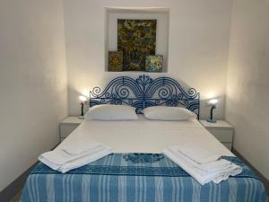 a blue and white bed with two towels on it at Le dimore di piazza torre in Torchiara