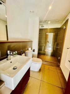 bagno con lavandino bianco e servizi igienici di Luxury room by Grand Vacations a Roches Noires