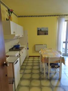 een keuken met een tafel en een tafel en een tafel en een tafel bij Appartamento Germano - Regina delle Alpi in Preinardo