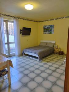 een slaapkamer met een bed en een flatscreen-tv bij Appartamento Germano - Regina delle Alpi in Preinardo