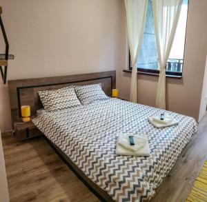 a bedroom with a bed with two towels on it at BoroHome in Borovets