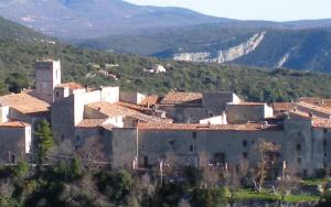 un grupo de edificios con montañas en el fondo en Le gite "lou quinsoun" en Mons