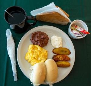 a plate of breakfast food with eggs potatoes and bread at Hotel Windsor Plaza in San Salvador