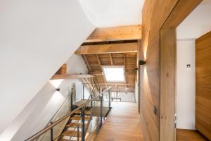 una escalera en una casa con paredes de madera y suelo de madera en Chalet-Ferienwohnung Giebeltraum, 115 qm, Wellness/Fitness/Sauna – Bergrödelhof en Feilitzsch