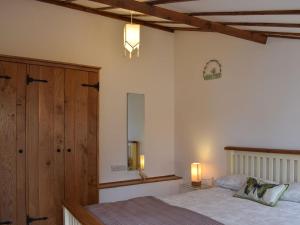 a bedroom with a bed and a dresser and a mirror at Pipers Stable in Nether Stowey