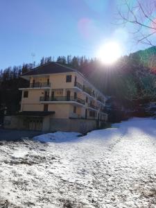 een gebouw in de sneeuw met de zon op de achtergrond bij Appartamento Germano - Regina delle Alpi in Preinardo