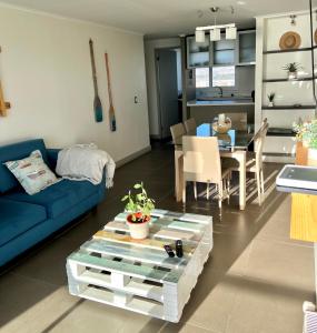 a living room with a blue couch and a table at Laguna del Mar, acogedor Depa para 6 in La Serena