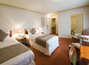 a hotel room with two beds and a couch at Old Hunstanton Le Strange Arms Hotel in Hunstanton
