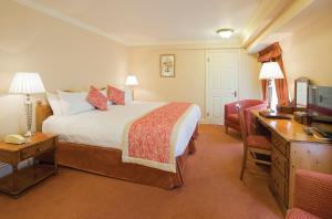 a hotel room with a bed and a desk with a computer at Old Hunstanton Le Strange Arms Hotel in Hunstanton