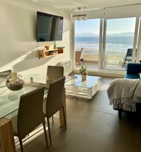 a living room with a table and a view of the ocean at Laguna del Mar, acogedor Depa para 6 in La Serena