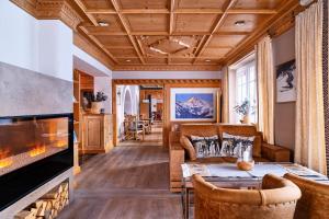 a living room with a fireplace and a couch at Hotel Hohenfels in Tannheim