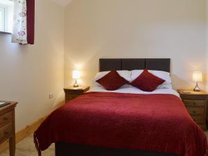 a bedroom with a large red bed with two lamps at The Parlour in Normanton on Trent
