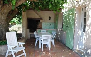 a table and chairs on a patio with a green door at Gite dans les vignes la calade in Grimaud