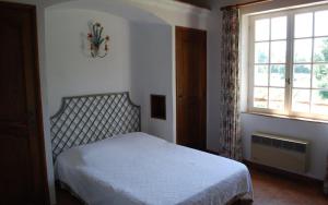 a bedroom with a white bed and a window at Gite dans les vignes la calade in Grimaud