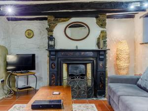 a living room with a fireplace and a couch at Laity in Polperro