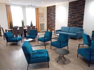 a waiting room with blue chairs and a table at Hotel Busby in Nice
