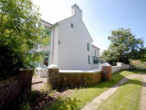 a white house with a fence at Rwgan in New Quay