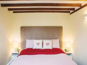 a bedroom with a large bed with two pillows at West Granary - 28957 in Eye