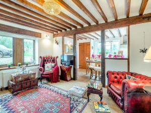 una sala de estar con muebles de cuero rojo y una mesa. en The Cottage en Arminghall