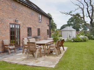 einen Holztisch und Stühle auf einer Terrasse in der Unterkunft Buddileigh Farm in Betley