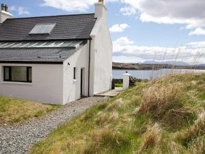 a white house on a hill next to a body of water at 7 Greep in Orbost