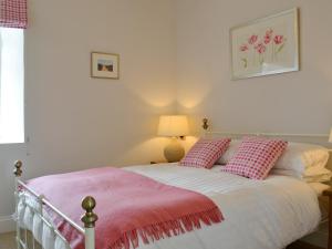a bedroom with a bed with pink and white pillows at The Chapel in Cyffic