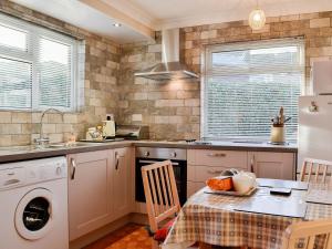 een keuken met een wasmachine en een tafel bij Briar Bank Bungalow in Cockermouth