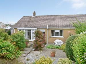 a small house with a garden in front of it at Briar Bank Bungalow in Cockermouth