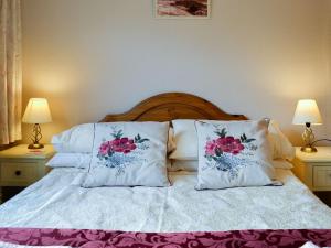 a bed with two pillows on it with two lamps at Briar Bank Bungalow in Cockermouth