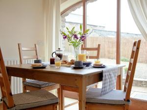 a dining room table with food and a vase of flowers at The Granary in Great Ormside