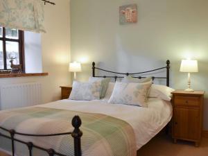 a bedroom with a large bed with two lamps at The Granary in Great Ormside