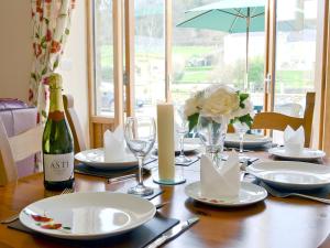 una mesa de comedor con una botella de vino y copas en The Dairy - Op3 en Carmarthen