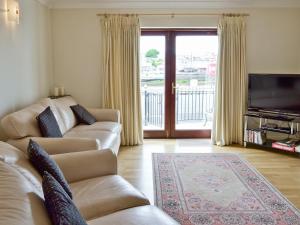 a living room with two couches and a television at Harbour View in Castletown
