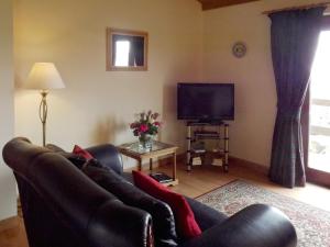 a living room with a couch and a television at Ben Alder Lodge in Milton