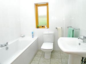 La salle de bains blanche est pourvue d'un lavabo, de toilettes et d'une baignoire. dans l'établissement Ben Alder Lodge, à Milton