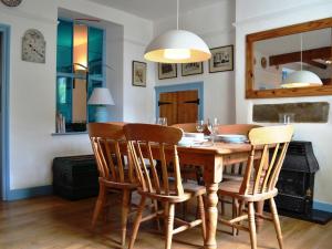 comedor con mesa de madera y sillas en Church Walk Cottage, en Kendal