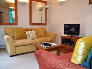 a living room with a couch and a tv at Church Walk Cottage in Kendal