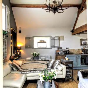 sala de estar con cama y sofá en The Old Parlour at Cheshire Boutique Barns, en Nantwich