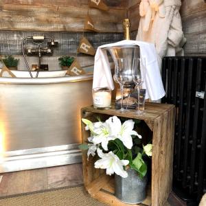 a table with a blender and a vase with white flowers at The Old Parlour at Cheshire Boutique Barns in Nantwich