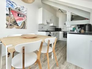 a kitchen and dining room with a wooden table and chairs at Seascape in New Quay