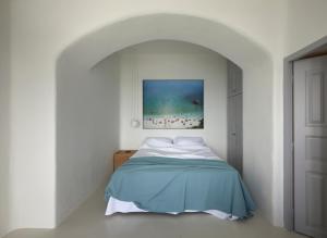 a white bedroom with a bed with a blue blanket at Inspire Santorini Luxury Villas in Fira